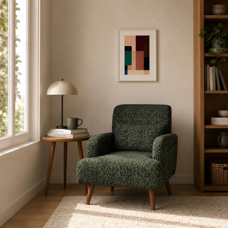 Dark green patterned accent chair with wooden legs in a cozy reading corner