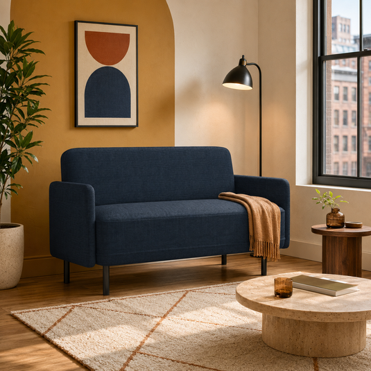Dark navy compact loveseat styled in a warm modern Brooklyn apartment.